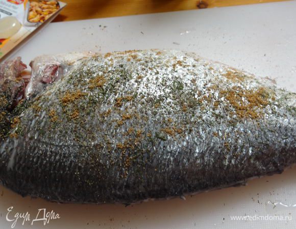 Натереть дораду изнутри и снаружи морской солью, смесью перцев и кориандром.