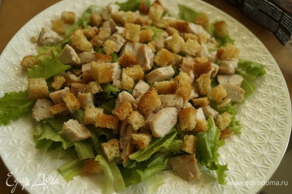 Зеленый салат порвать руками на кусочки и выстелить на тарелку. Положить куриное филе, порезанное кубиками, и сухарики.