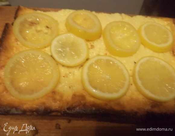 Лимон тщательно вымыть, нарезать тонкими кружками, выложить в маленькую кастрюльку, засыпать сахаром, влить воду и проварить на маленьком огне  около 10 минут. Выложить кусочки лимона на испечённый чизкейк. 
Очень вкусно!!!