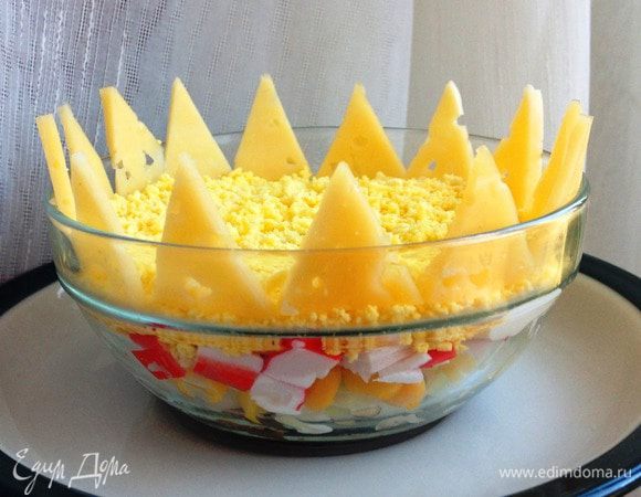 Еще оригинальнее этот салат будет смотреться в случае порционной подачи. Для этого все слои в такой же последовательности выложить по индивидуальным бокалам. Сыр нарезать треугольничками и разместить их в виде короны вдоль стенок бокала.