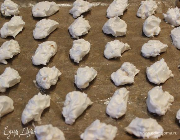 Противень застелить пекарской бумагой (можно смазать маслом) и с помощью двух чайных ложек выложить белковую массу, не обращая внимания на внешний вид меренг.