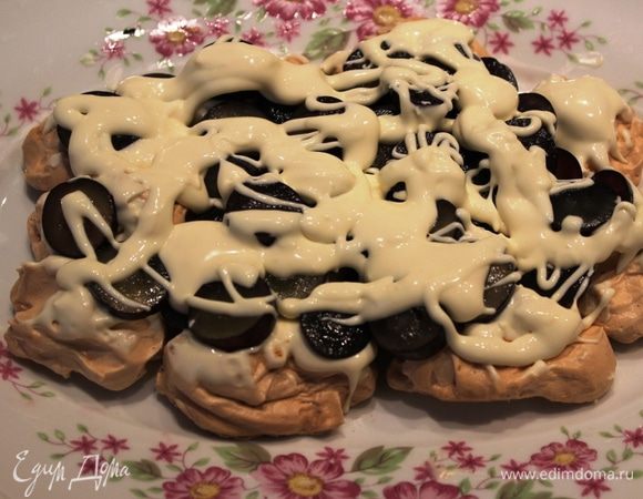 После остывания меренг можно собирать торт: на плоское блюдо выложить в один слой меренги, прижимая их плотно друг к другу. Нанести первую порцию крема и часть винограда. Поверх винограда снова нанести крем.