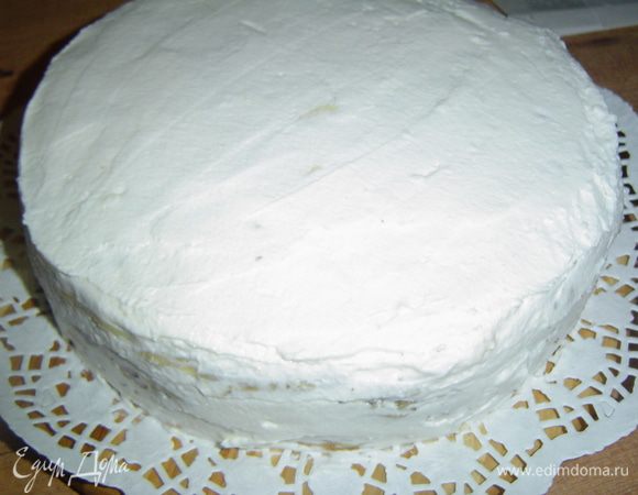 Сливки взбиваем с сахарной пудрой до устойчивых пиков, а потом смазываем ими бока и верх торта. Сверху посыпаем измельченными орехами.