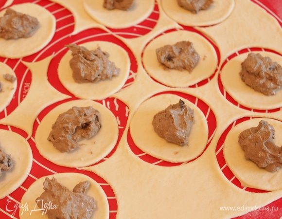 Тесто тонко раскатать, вырезать стаканом кружки. На каждый кружок выложить чайную ложку начинки и сформировать пирожки. 