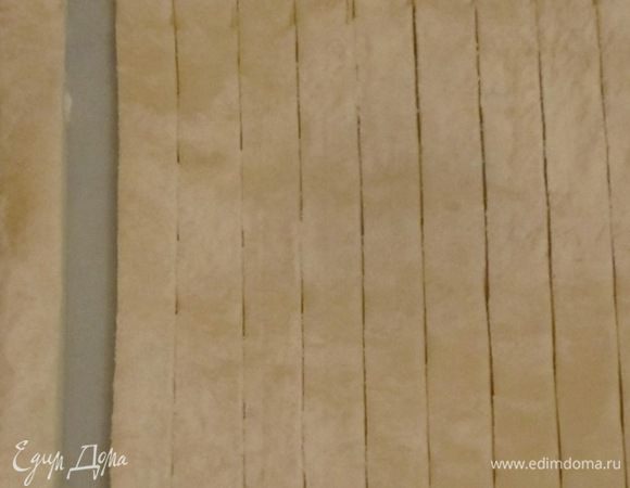 Тесто разморозить. Немного раскатать и нарезать на полоски шириной 1 см.