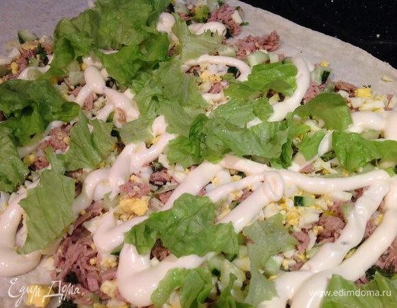 Лаваш развернуть, выложить яйца, огурцы, зелень, тунца. Полить майонезом. Сверху порвать листья салата.