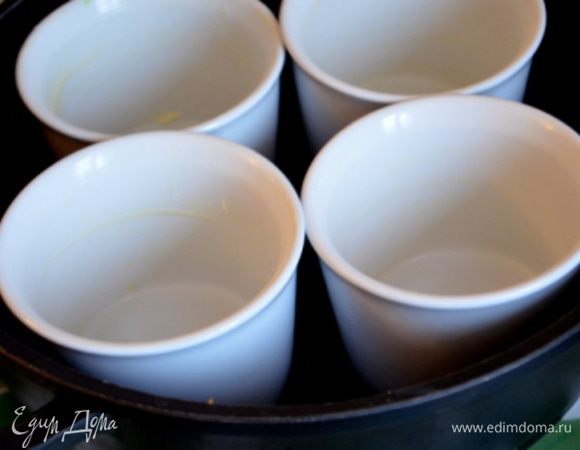 Формочки для суфле (или 1 большую) смазать оставшимся сливочным маслом, поставить их в бОльшую форму и влить горячую воду до половины маленьких формочек).