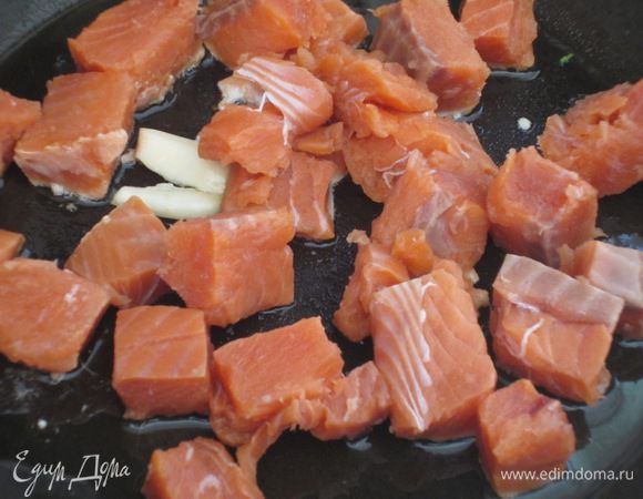 В сковороде разогреть 2 ст.л. оливкового масла с зубчиком чеснока и обжарить лосось на среднем огне. Влить 30 мл белого вина, посолить, поперчить, добавить  измельчённую петрушку, готовить ещё несколько минут и снять с огня.