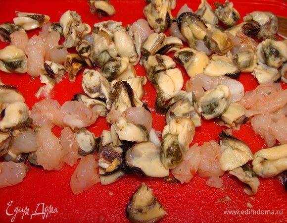 Морской коктейль разобрать на две части. В одной должны быть креветки и мидии, в другой кальмары и осьминоги. Креветки с мидиями порезать пополам и протушить вместе с перцем. Если надо, присолить и поперчить. В самом конце добавить 1 с/л сливок и тертый пармезан.