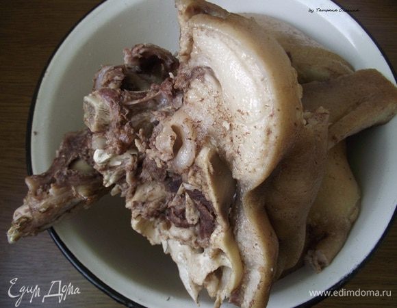 Самый кропотливый этап — очистка свиной головы. Свиную голову нужно хорошо вымыть, обрезать щеки. Разрубить голову на несколько частей, удалить мозг, глаза, обрезать шкурку в тех местах, где она вам не нравится. Затем замочить в холодной воде на 12 часов, обязательно несколько раз меняем воду. Голову и мясо отправляем на плиту и доводим до кипения, сливаем первую воду. Затем снова отправляем на плиту и варим около 2 часов, а к окончанию варки добавляем перец горошком, лавровый лист, лук, морковь, соль по вкусу — готовим до тех пор, пока мясо не начнет отделяться от костей. Остужаем свинину и отделяем от костей. 