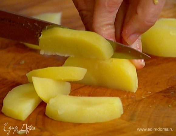 Картофель отварить в мундире, затем почистить и нарезать дольками.