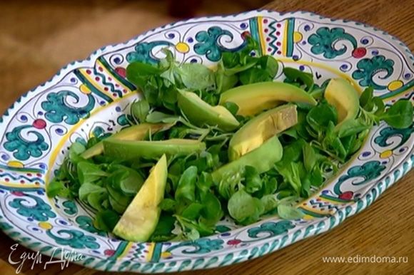 Выложить на большое блюдо салатные листья, а сверху авокадо, сбрызнуть все лимонным соком (1 ст. ложку оставить для заправки).