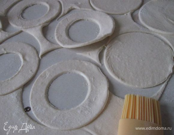 Из половины вырезанных кружочков сделать колечки, вырезав тесто стаканом или рюмкой более маленького диаметра.

