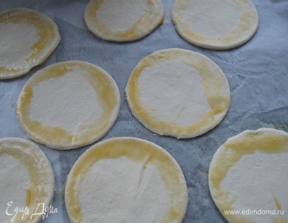 На противень, застеленный пекарской бумагой, положить сначала кружочки теста, смазать края взбитым яйцом.