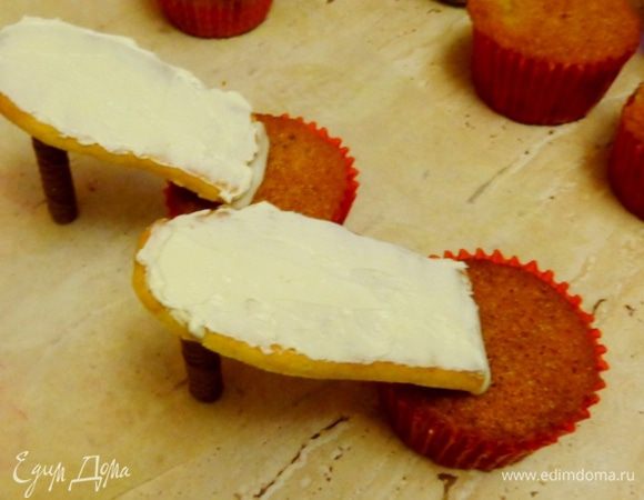 Из готовых магазинных трубочек сделать каблучки, склеить их с подошвой, а подошву с кексом при помощи айсинга. Дать застыть айсингу.