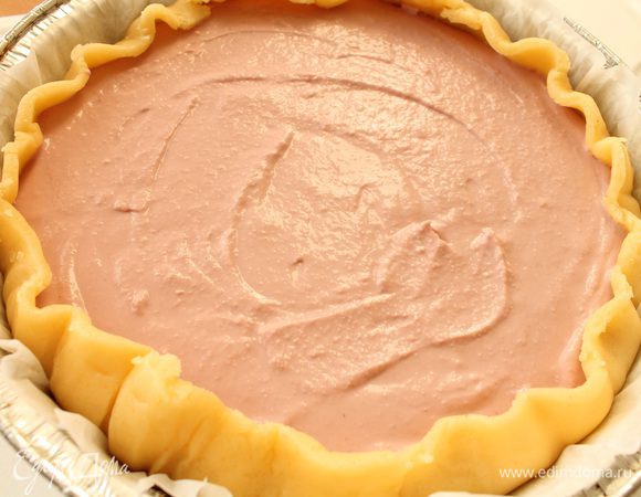 Достать тесто из холодильника,  раскатать в круг на бумаге для выпечки, перенести в форму, сформировать бортик, через ситечко присыпать крахмалом. Распределить творожную смесь, бортики слегка загнуть внутрь.