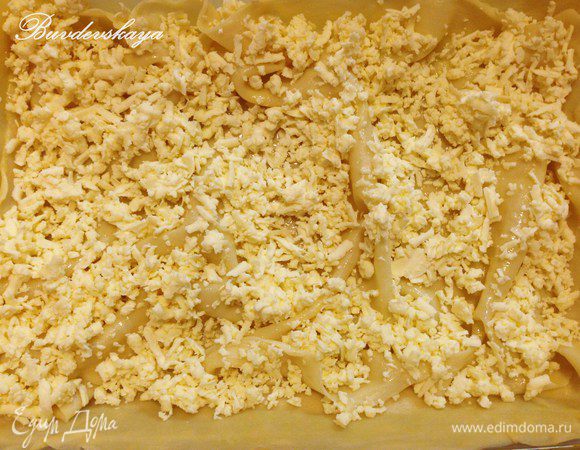 Сверху присыпать натертым сыром, накрыть следующим отварным пластом теста, смазать маслом и опять выложить сыр и так продолжить с остальными слоями до конца Ачмы. Если Вы хотите, чтобы верхний слой был хрустящим, то его не нужно отваривать. А если мягким, то его также необходимо отварить. В любом случае, последний слой необходимо смазать растопленным маслом.