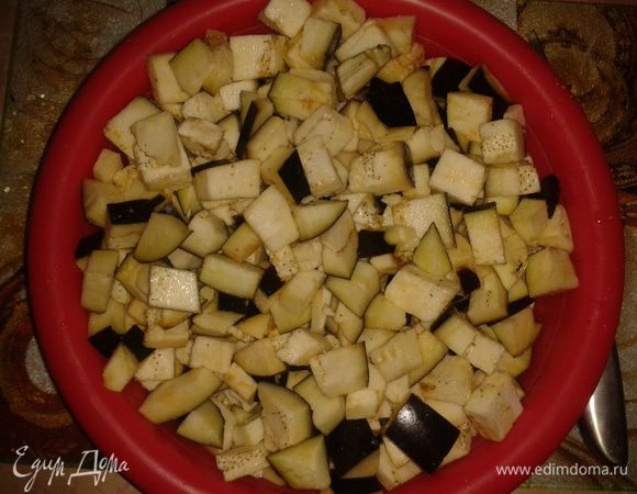 Баклажаны вымыть, нарезать кубиками, посолить и оставить в тарелке (это необходимо, чтобы убрать горечь).