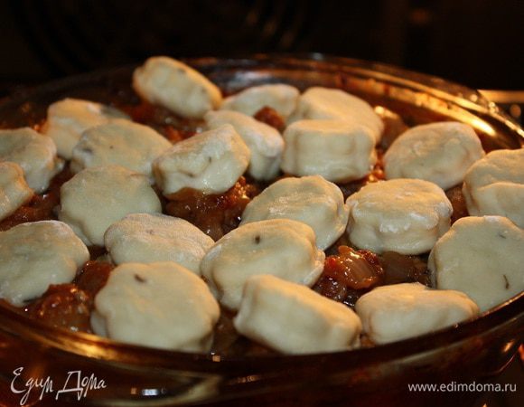 Через 1,5 часа духовку разогреть до 240 градусов. Крышку с мяса убрать. Пышки выложить прямо на мясо. Не очень плотно, так как они увеличатся в объеме.