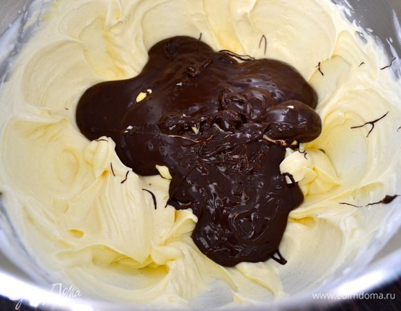 Затем добавить в крем взбитые желтки и расплавленный шоколад. Осторожно перемешать, чтобы масса не осела. 