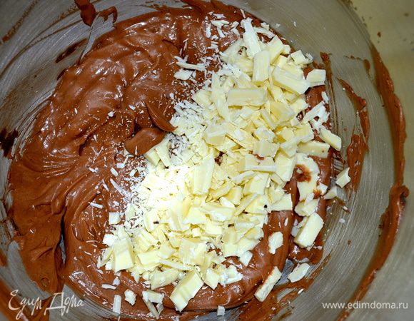 Белый шоколад нарезать не очень мелкими кусочками и добавить в крем. Перемешать.