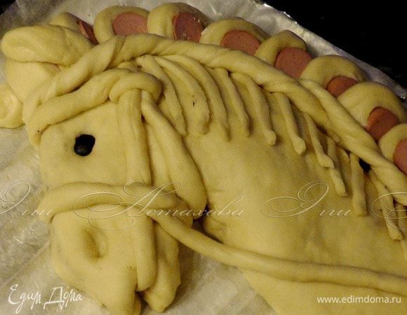 Из оставшегося теста формирую ушки, волосы, уздечку и поводья.

Соединение между гривой и головой украшаю полосками перекрученного теста. Глаз из обычно маслины. Ноздря – обычное углубление.