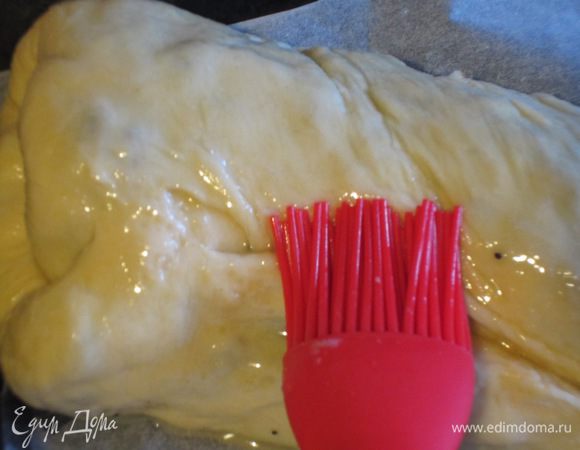 Выложить рулет на противень с пергаментом, смазать оставшемся сливочным маслом и выпекать в разогретой до 180 °С духовке 1 час.