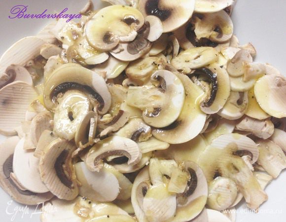 2.	Шампиньоны помыть, обсушить и нарезать на тонкие ломтики. Можно воспользоваться слайсером. Затем выложить в глубокую миску, залить половиной заправки. Аккуратно перемешать и оставить мариноваться на 7-10 минут.