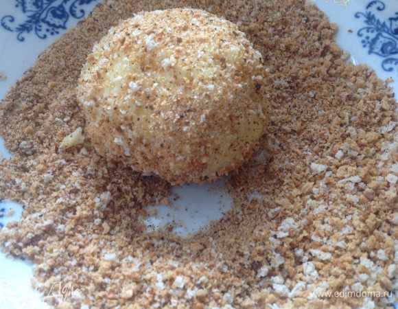 Разделить картофельное тесто на 7 шариков, обвалять каждый в панировочных сухарях. Уложить в форму, смазанную сливочным маслом.
