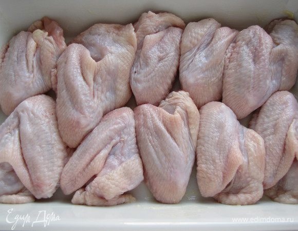 Смазать глубокую форму для запекания 0,5 ст. л. сливочного масла, уложить в нее крылышки.