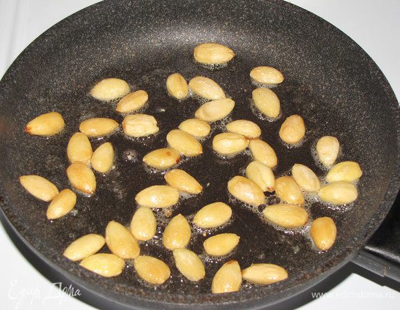 В сковороде разогреть оставшееся сливочное масло, положить миндаль и обжарить до золотистого цвета.