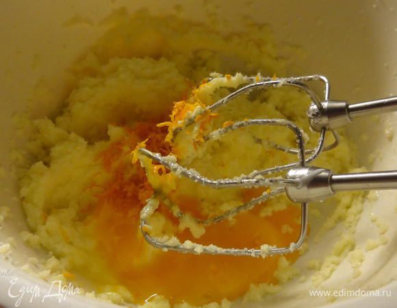 Добавить желтки и цедру апельсина.