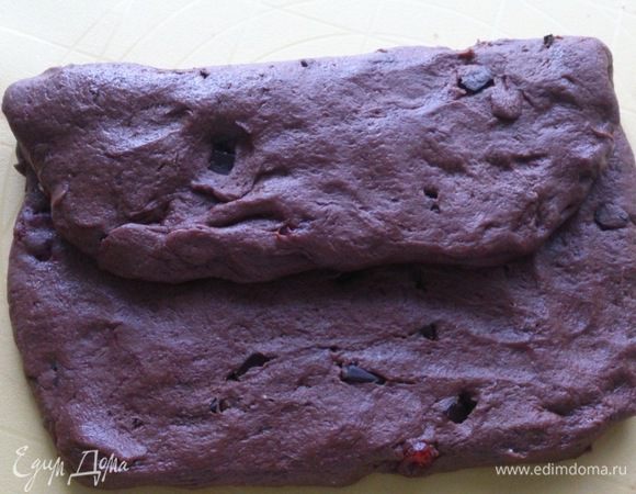 Разделить тесто на 2 части, раскатать в пласт около 2 см толщиной. Один край завернуть внутрь, чуть больше, чем до середины.