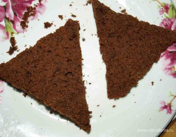 Если корж выпекался в большой форме, а не порционно, то его разрезаем на порции. Срезаем осторожно верх (1 см). 