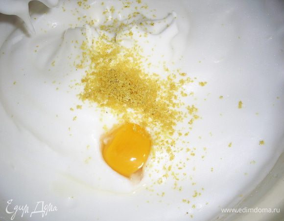 На мелкой терке натираем лимонную цедру (только желтую часть), выдавливаем сок. 
Ко взбитым белкам добавляем  лимонный сок, цедру и по одному добавляем желтки. После каждого желтка тщательно взбиваем массу до однородности.