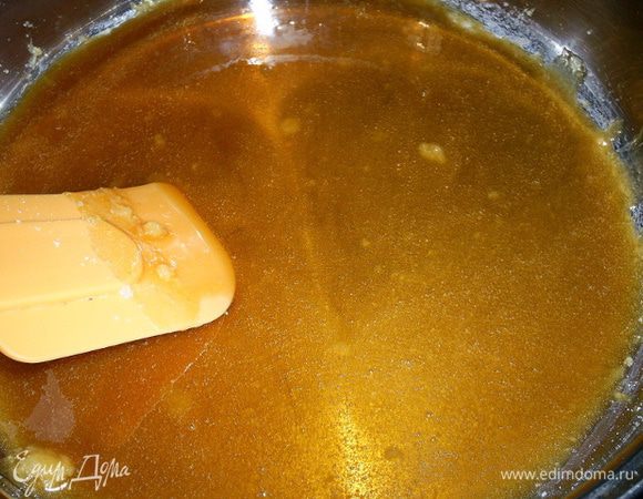 Займемся карамельной прослойкой. Сахар высыпаем в сотейник или сковороду с толстым дном и начинаем нагревать на среднем огне. Сахар начнет таять сначала возле стенок посуды. Желательно его ничем не мешать, можно слегка встряхнуть сотейник, чтобы сахар прогревался более равномерно. Держим на огне до получения золотисто-янтарного цвета. Не передержите, а то будет горчить и пахнуть жженым сахаром.