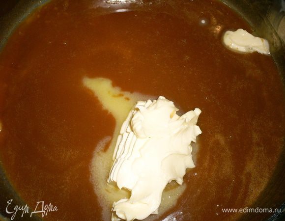 Снимаем сотейник с огня и постепенно, все время помешивая вливаем теплое молоко. Делать это нужно очень аккуратно, так как карамель будет сильно пениться и брызгаться. Если влить сразу все молоко, карамель соберется в комок. Ничего страшного - возвращаем сотейник на огонь и помешиваем до полного растворения карамели. Затем снимаем готовую карамель с огня и добавляем масло. Перемешиваем до однородного состояния.