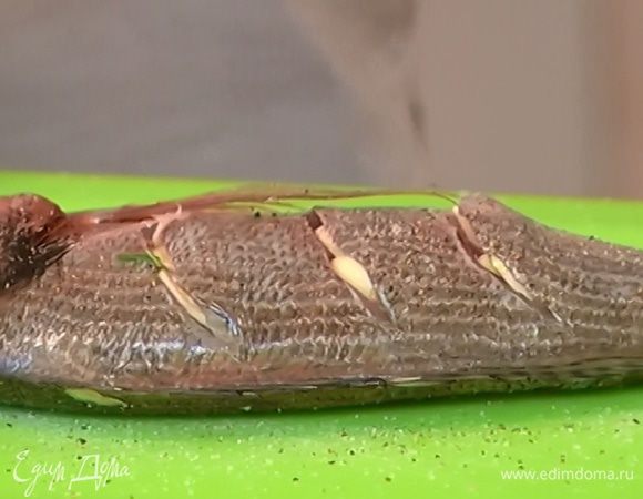 Рыбу посолить, поперчить и сделать ножом по 3–4 неглубоких косых надреза с каждого бока тушки, не прорезая до хребта. 