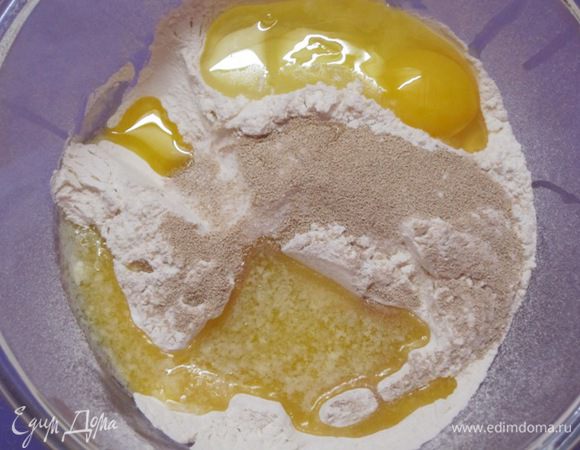 Просеять муку, добавить соль, сахар, растопленное сливочное масло, яйцо и сухие дрожжи.