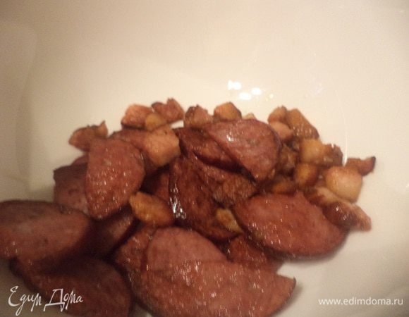 Колбасу нарезать тонкими ломтиками и вместе с беконом обжарить на 1 ст. л. растительного масла. Обжаренные колбасу и бекон выложить на тарелку.