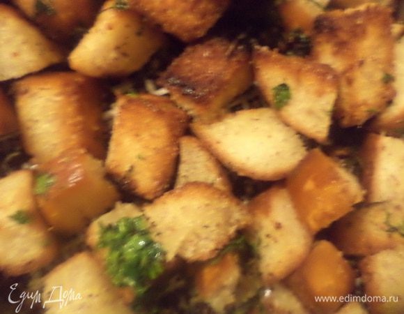 На сковороду, где жарились бекон и колбаса, добавить ещё 2 ст. л. растительного масла и выложить кусочки хлеба, подрумянить хлеб. Добавить рубленую петрушку и обжарить .