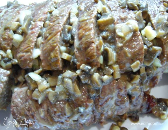 С мяса убрать кулинарную нить.
Нарезать мясо поперек, но не до конца (как раскрытая книга). 
В каждый разрез положить соус с грибами.
