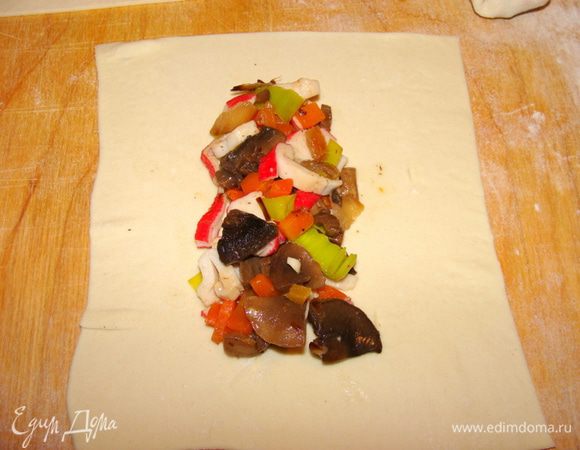 Нам понадобится 2 пачки готового слоеного теста. Разморозить его и раскатать. нарезать прямоугольниками. Из одной пачки примерно 12 штук. На середину прямоугольника выложить салат, 1.5-2 ст.л.