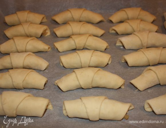 Выкладываем рогалики на противень хвостиком вниз. Выпекаем в разогретой духовке 15-20 минут при температуре 180°С. Готовые рогалики посыпаем сахарной пудрой.