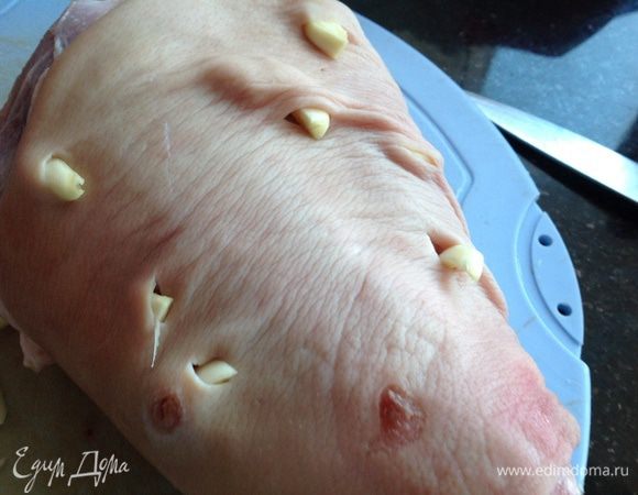 Свиную рульку очистить, обмыть, обсушить, сделать надрезы и вставить в них чеснок, натереть солью и перцем.