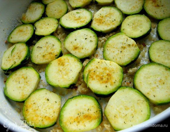 Выкладываем первый цукини одним слоем, сверху приправа.