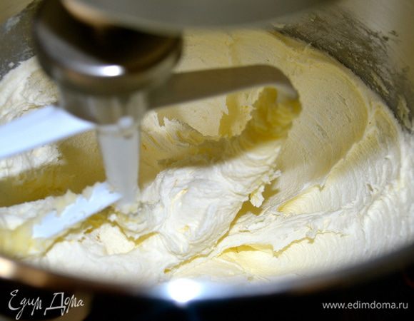Затем в чаше кухонного комбайна взбить размягченное сливочное масло с 200 г сахарной пудры и ванильным сахаром до кремового состояния.