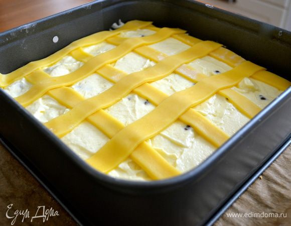 Оставшееся тесто раскатать в тонкий пласт и нарезать полоски шириной в 1 см. Выложить полоски теста поверх начинки «решеткой».