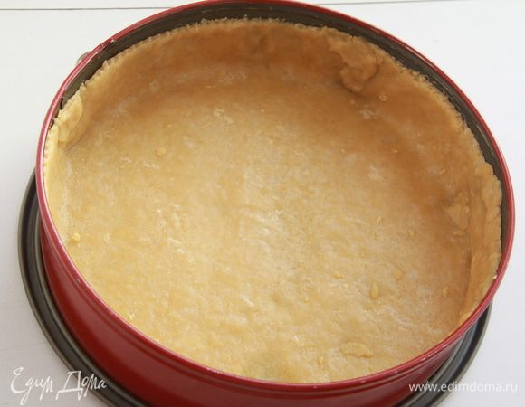 Тесто раскатать, я делаю это через плотную плёнку, затем прямо с плёнкой перенести тесто в форму, прижать по всей поверхности, плёнку убрать, края обрезать с помощью ножа для равиоли. Бортики должны быть достаточно высокими, чтобы поместилась начинка и не вытекла заливка. Выпекать корж при 180*С примерно 15 минут (бобы для выпечки я не клала, тесто не вздувалось).