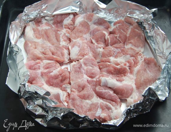 Свиную шейку нарезать на порционные куски, слегка отбить, посолить-поперчить с обеих сторон, выложить на двухслойную фольгу, с бортиками. 